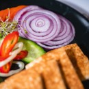 Homemade eggplant cream with fresh vegetables on pizza pane