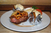Beef tenderloin steak coated with bacon, served with fried mushrooms, smoked cheese, remoulade sauce, baked potatoes