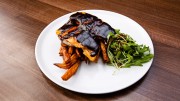 Cheddar-baked BBQ sous-vide chicken breast with sweet potato fries, and arugula salad with smoked, sweet roasted onion dressing (lactose, vinegar)