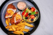 CHICKEN BREAST STUFFED WITH CHEDDAR CHEESE AND BLACK FOREST HAM, GRILLED IN PANKO CRUMBS WITH „EZERSZIGET” DRESSING, MIXED SALAD AND CRISP BOAT-FRIES
